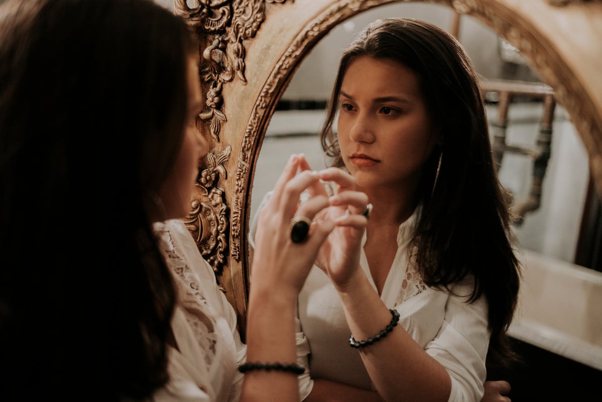 Woman looking at reflection in mirror